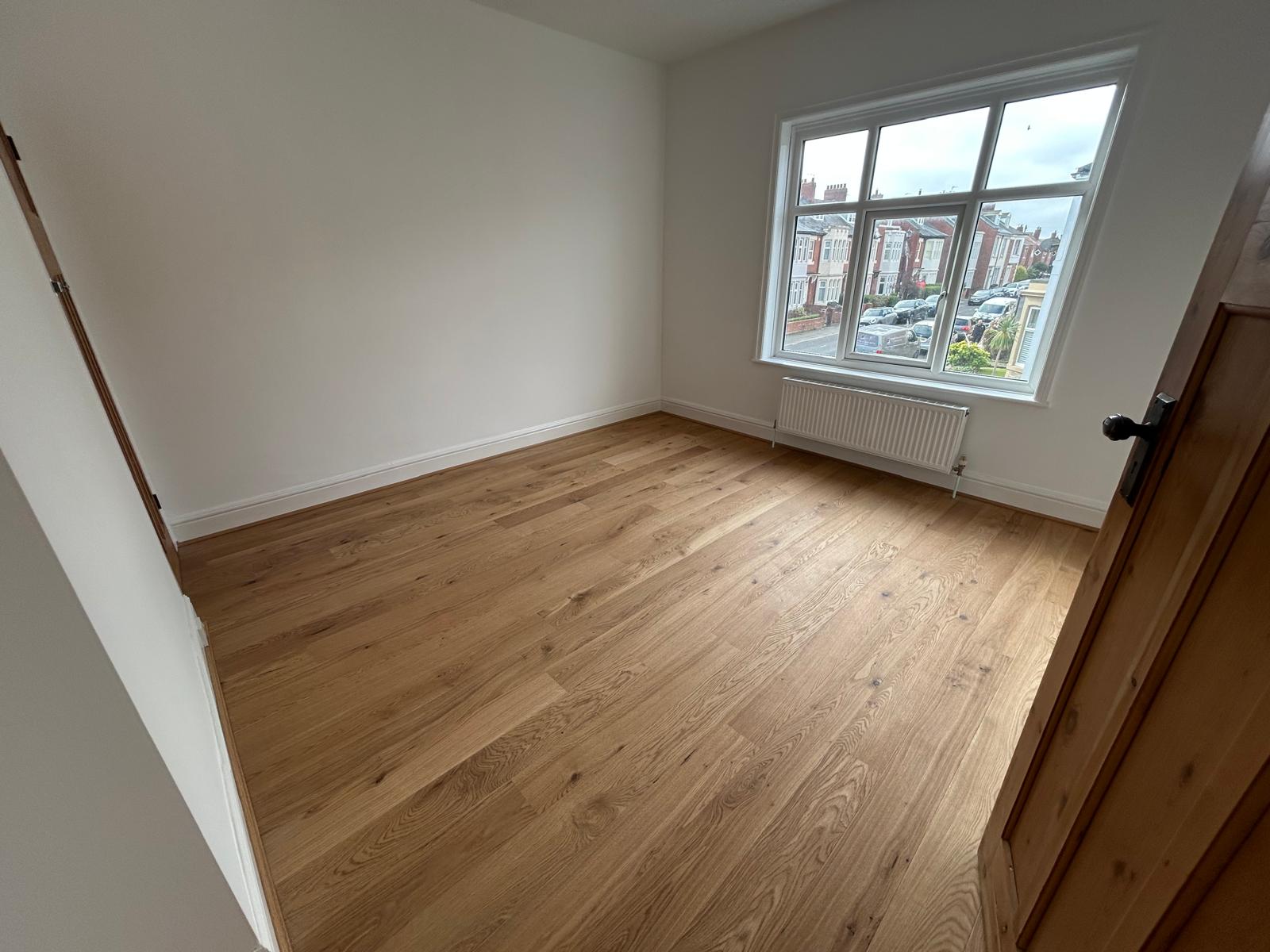 Bright bedroom with new engineered oak flooring and freshly painted walls