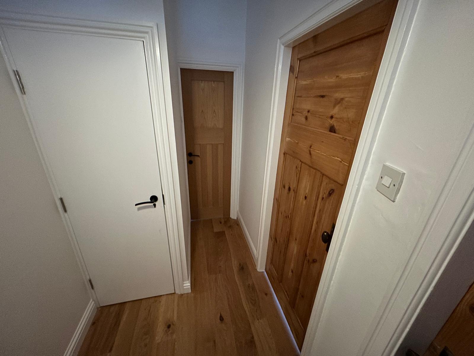 Landing with restored pine doors and oak flooring