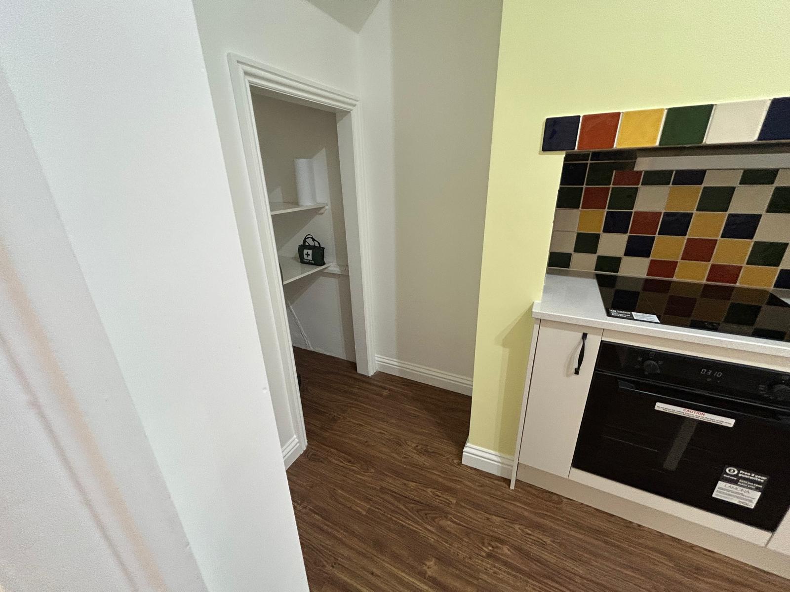 Renovated kitchen with patterned tiled splashback, induction hob and built-in oven